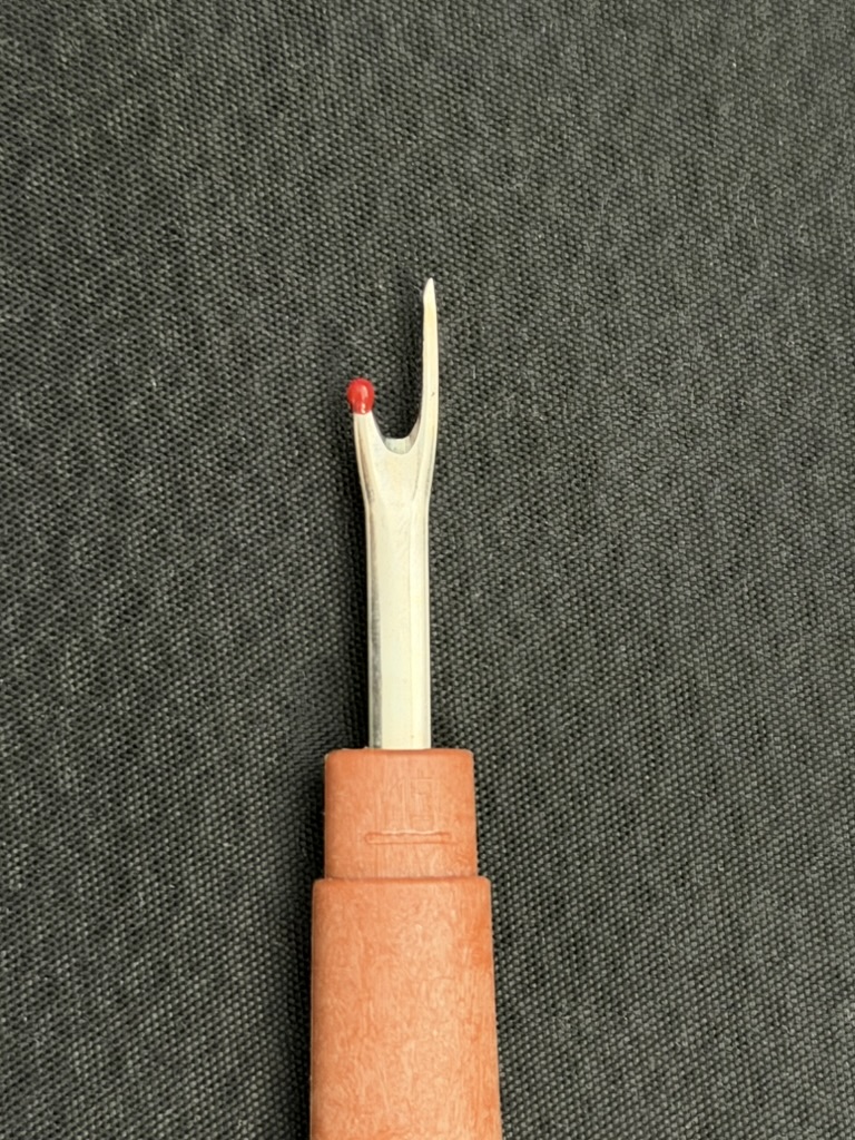 Nahtauftrenner mit orangefarbenem Griff und roter Schutzkugel